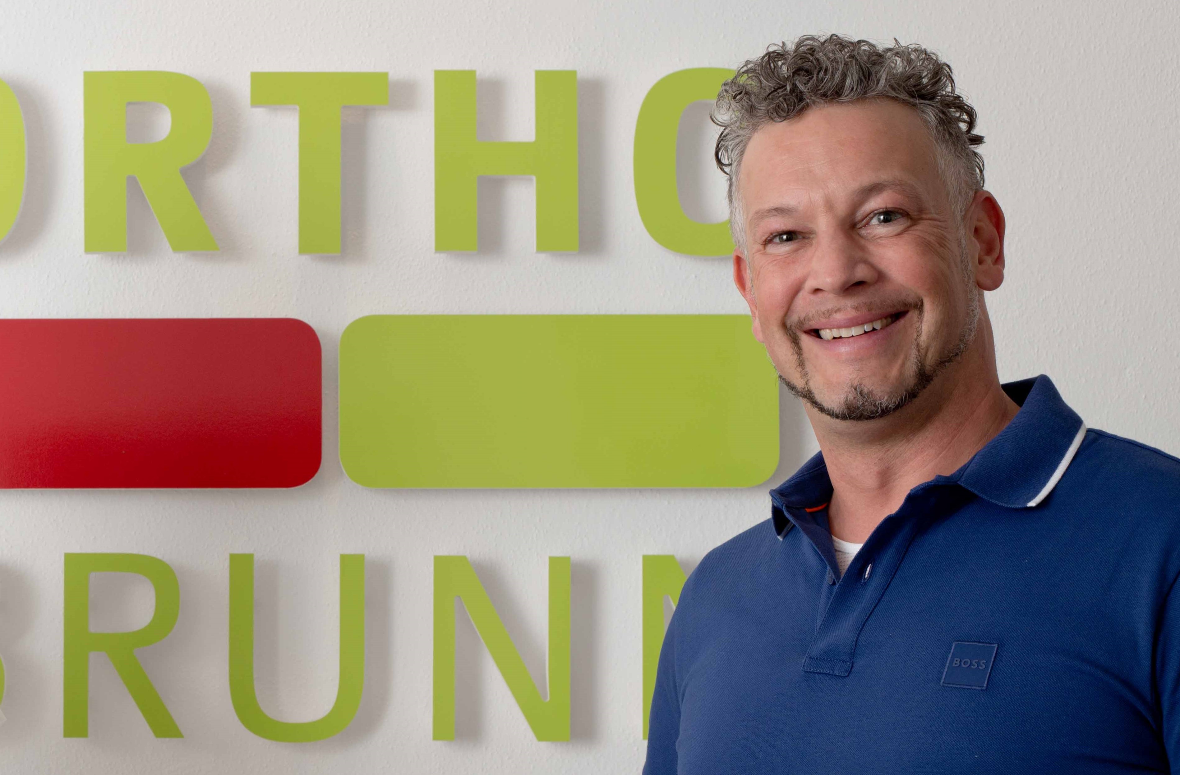 Dr. Holger Hoffmann mit OrthoBrunn Logo